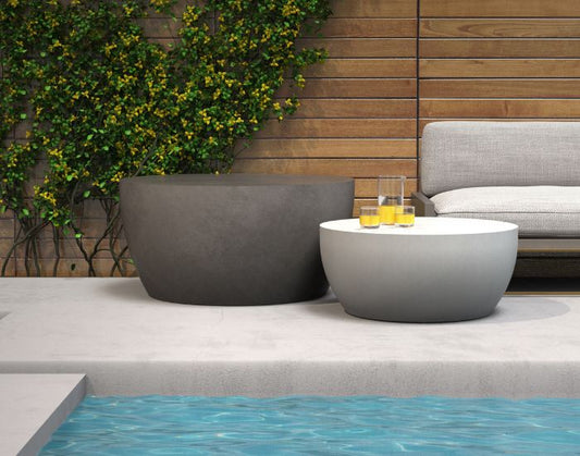 View of the Blinde Design Circ m2 coffee tables in the colours natural and bone next to a pool