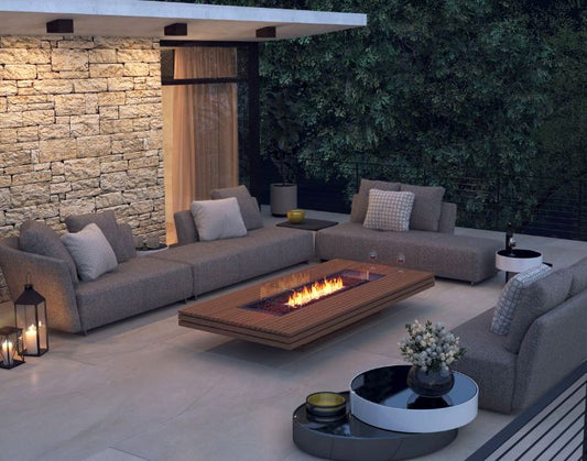 View of a porch with the EcoSmart Fire Gin 90 (Low) Bioethanol Fire Pit Table in the colour teak with a fire screen 