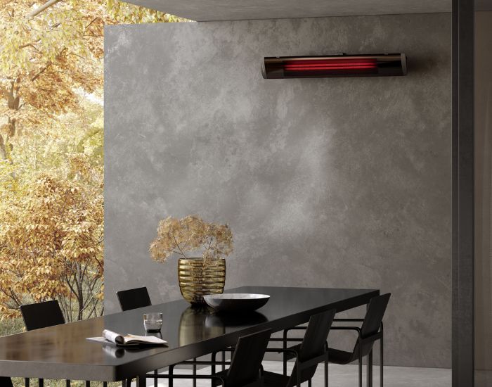 View of a garden with the Heatscope Pure 2400w Radiant Heater in the colour black mounted on a wall
