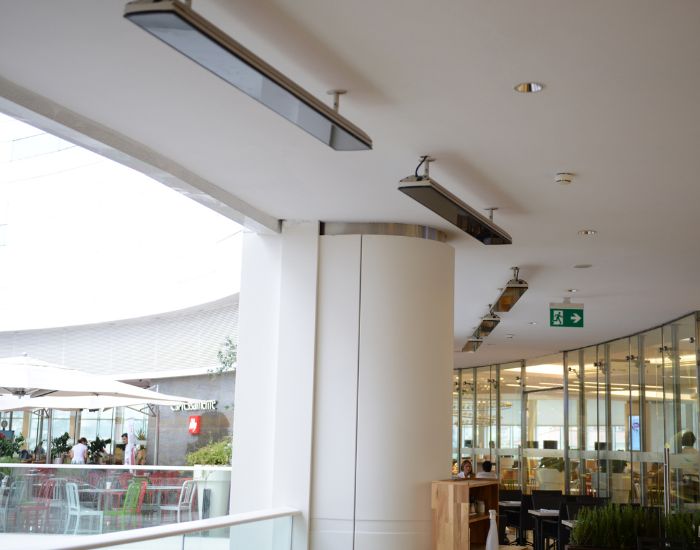 View of a shopping centre with several Heatscope Vision 3200w Radiant Heaters in the colour black mounted on the ceiling