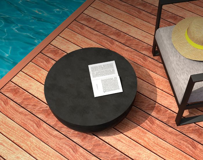 View of the Blinde Design Circ L2 concrete coffee table in graphite next to a pool