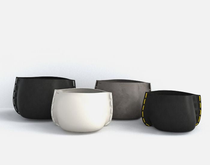 Studio view of the Stitch concrete planters in different sizes and different colours: graphite, natural and bone